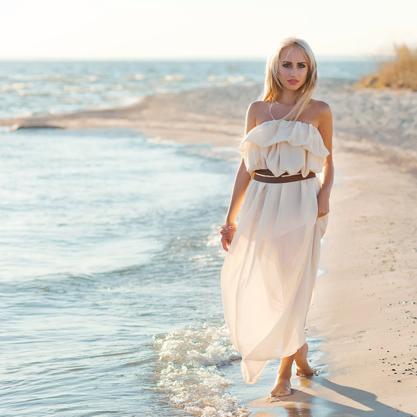 Beautiful girl walking down the beach - Fotoğraf, Görsel