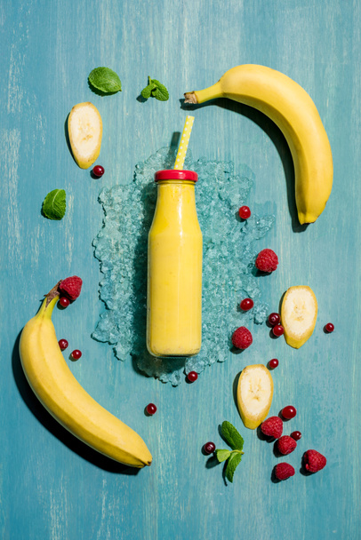 bottle with smoothie and berries - Фото, изображение