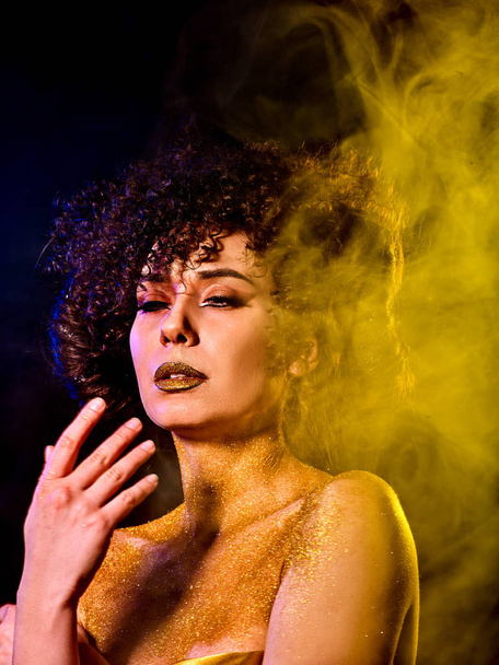 Cosmética dorada en polvo sobre hombros desnudos de mujer con decoración
 - Foto, imagen