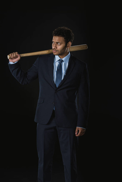 Serious businessman with bat  - Foto, afbeelding