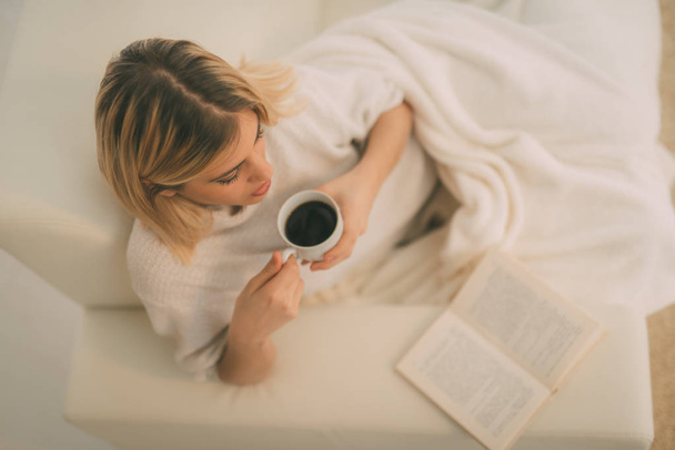 vrouw met koffie en boek ontspannen - Foto, afbeelding