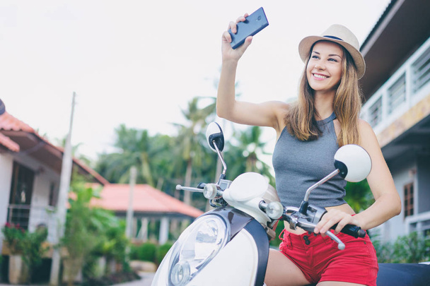 woman on scooter using smartphone - Zdjęcie, obraz
