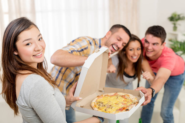 ystävät nauttivat pizzaa yhdessä
 - Valokuva, kuva