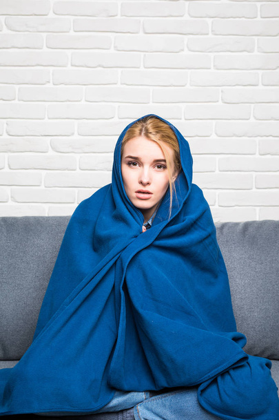 Donna malata ottenere freddo con coperta sulla testa seduto sul divano a casa
, - Foto, immagini