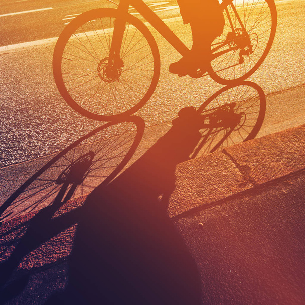 Riding bicycle, shadow - Foto, afbeelding