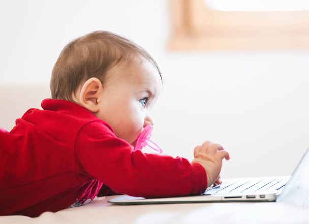 Baby tyttö käyttää kannettavaa tietokonetta
 - Valokuva, kuva