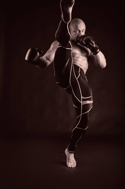 A man with a gorgeous muscular body on a black background - Fotó, kép
