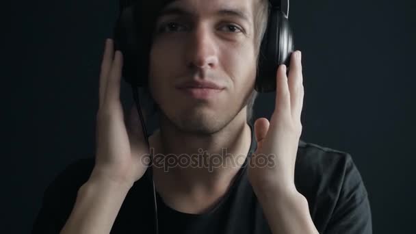 Young man listening to music on headphones. Slow motion shot - Footage, Video