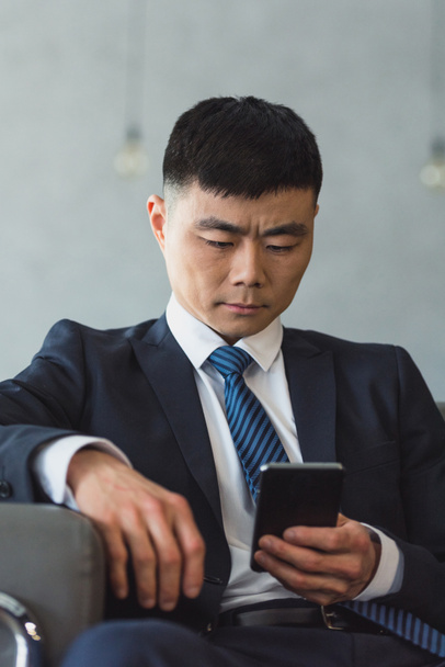 Азиатский бизнесмен с помощью смартфона
 - Фото, изображение