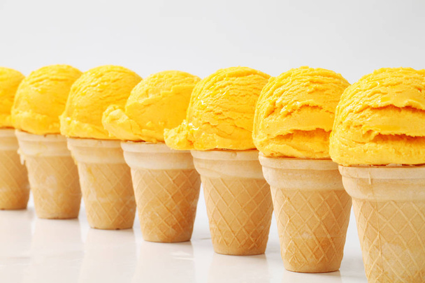 Cônes de crème glacée jaune dans une rangée
 - Photo, image