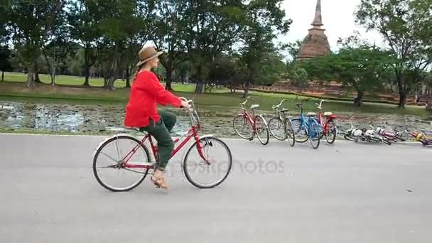 Nainen polkupyörän kanssa lähellä raunioita Thaimaassa
 - Materiaali, video