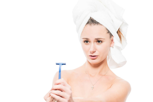 Nuori nainen suihkun jälkeen ja partaveitsi valkoisella taustalla
 - Valokuva, kuva