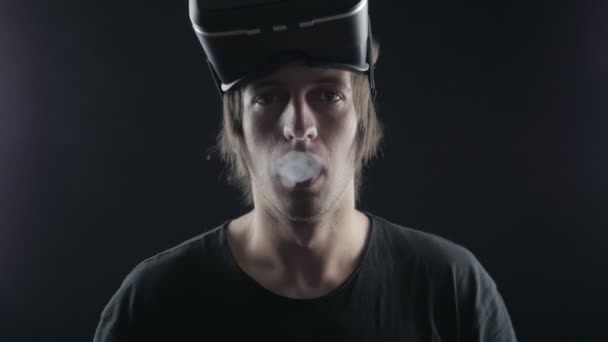 hombre fuma un cigarrillo electrónico y utiliza un casco de realidad virtual. Vaper futurista
 - Imágenes, Vídeo