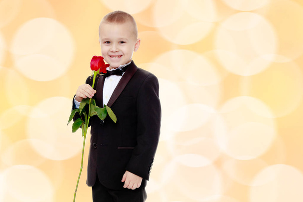 Little boy with a rose flower. - Fotó, kép
