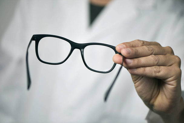 gözlükçü adam bir çift gözlük getirmek - Fotoğraf, Görsel