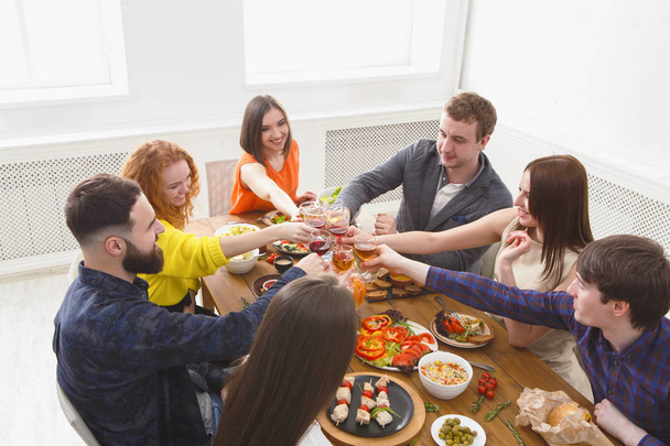 Mensen zeggen cheers clink bril op feestelijke tabel diner - Foto, afbeelding