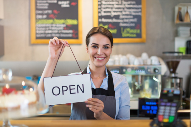 Woman holding open sign in cafe - Foto, Bild