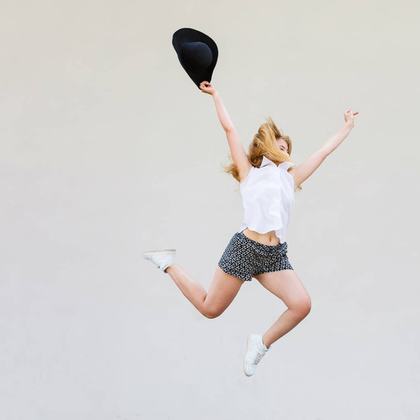 Woman in summer clothes jumping with sun hat - Foto, Imagem