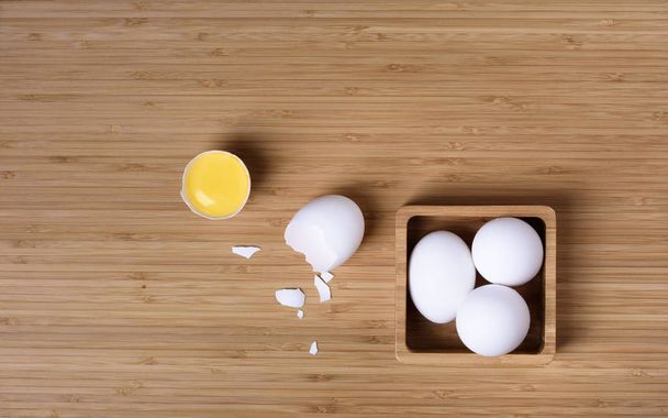 Eggs on a cement background. Crushed egg with a yolk.  - Φωτογραφία, εικόνα