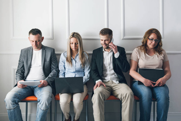 Group of creative people sitting on chairs in waiting room - Photo, image