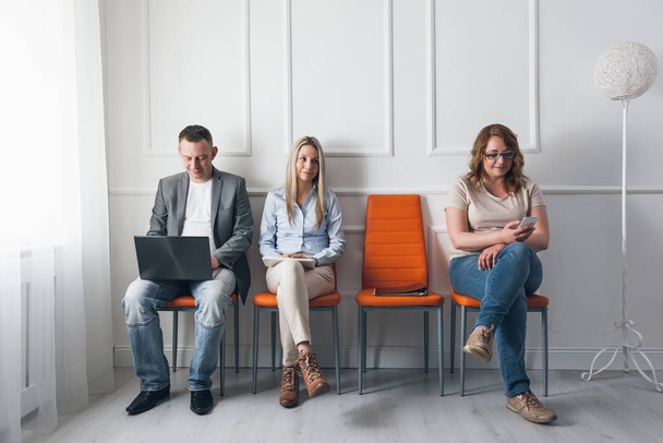 Group of creative people sitting on chairs in waiting room - Foto, Imagen