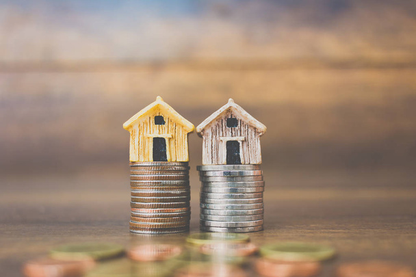 Монети і модель будинку на дерев'яному фоні
  - Фото, зображення