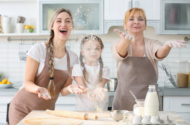 woman with mother and daughter cooking  - Фото, изображение