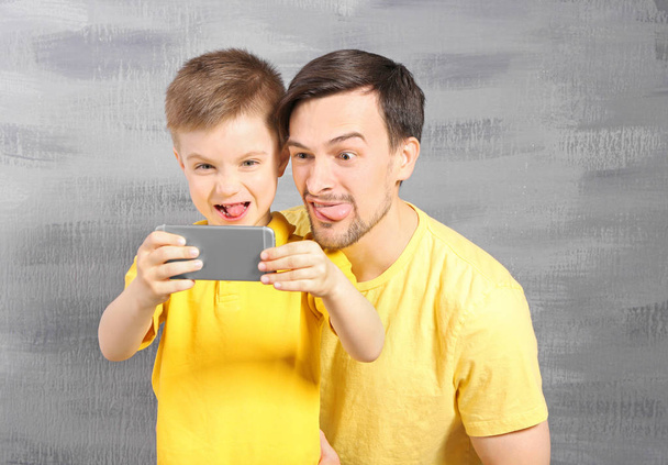 Handsome man and son taking selfie  - Фото, зображення