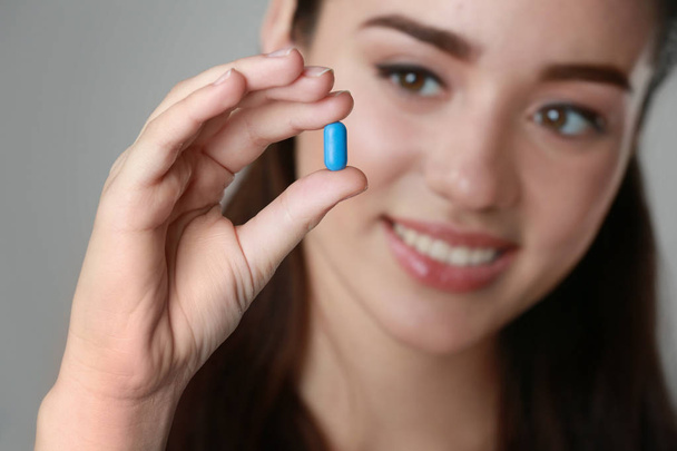 Beautiful young woman with pill  - Foto, Bild