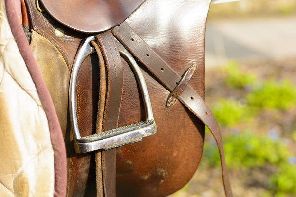 Closeup lederen cowboy zadels opknoping op de reling - Foto, afbeelding