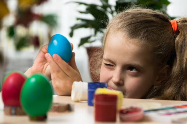 Niña caucásica niño dibujar huevos antes de las vacaciones de Pascua
 - Foto, Imagen