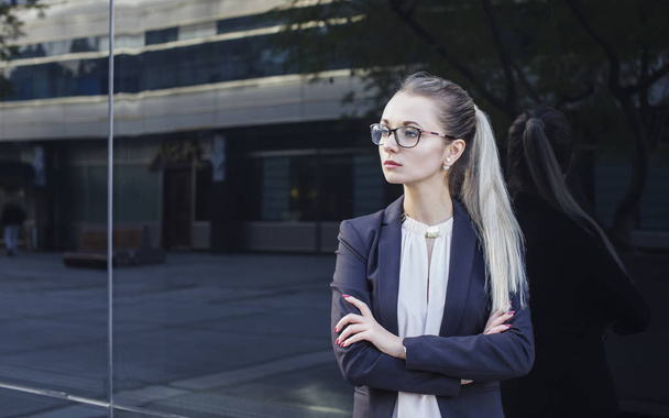 Serious young woman in suit and glasses - 写真・画像