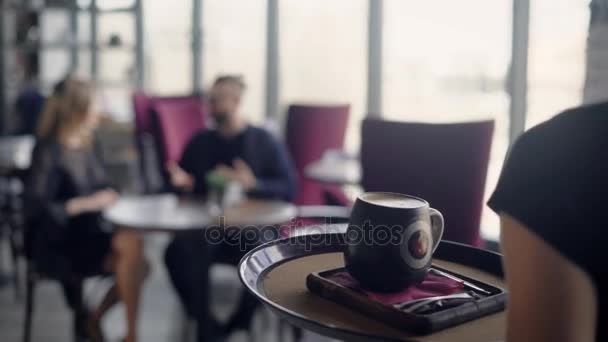 The waiter wears a large cappuccino cup for the young couple on the tray, who performs an aperitif in a restaurant, a man and a woman talk about the past weekend - Filmagem, Vídeo