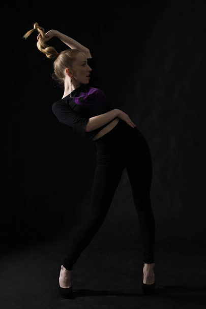 Vogue χορεύτρια που ποζάρει σε σκούρο φόντο - Φωτογραφία, εικόνα
