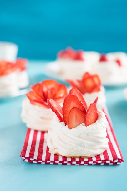 A small meringue Pavlova dessert with some strawberry slices - Fotó, kép