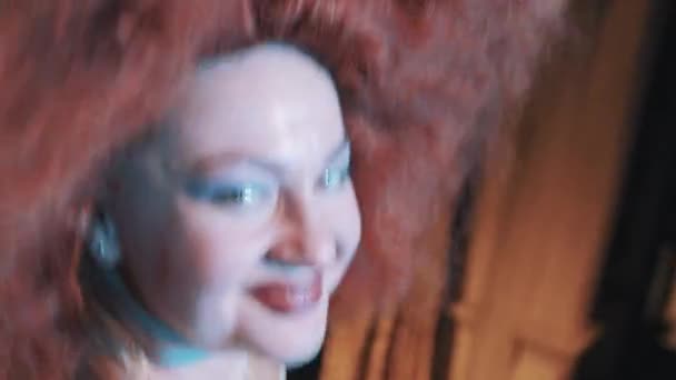 Woman in lush rufous hair wig grimacing and dancing on scene with troupe - Séquence, vidéo