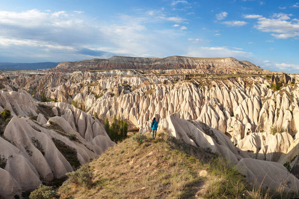 The girl looks at the wonderful landscape of Cappadocia in Turkey, near Goreme. Pink and Red Valley - Photo, Image