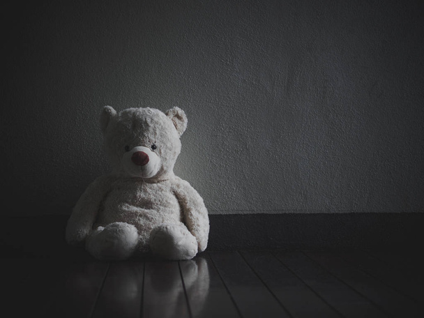 Lonely Teddy Bear Sitting in the dark room (Concept about love) - Photo, Image