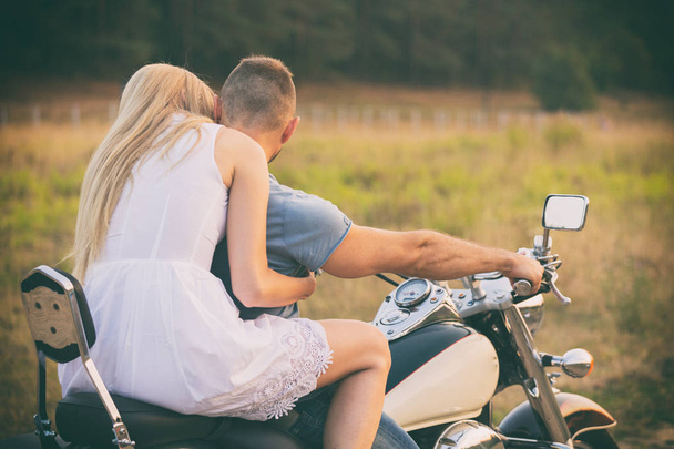 フィールドでバイクに愛情のあるカップル - 写真・画像