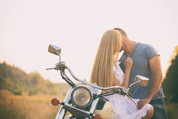 Любящая пара на мотоцикле в поле
 - Фото, изображение