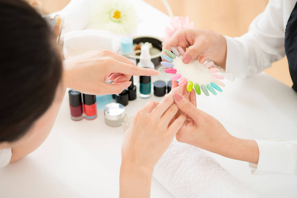 woman selects color shellac nail polish - Valokuva, kuva