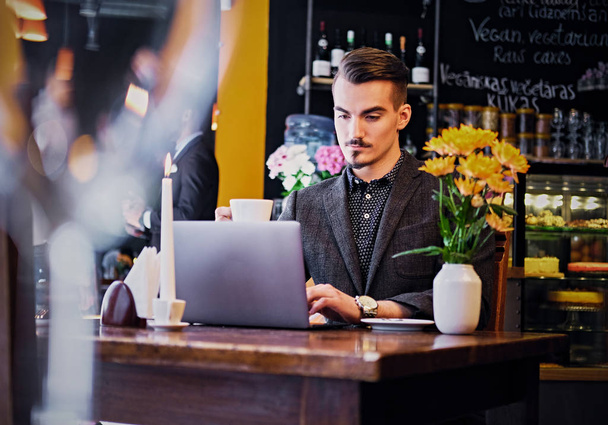 Homem usando laptop em um café
 - Foto, Imagem