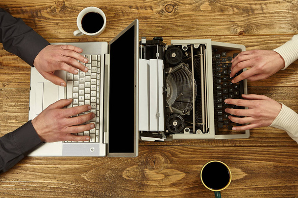 Nainen kirjoittaa kirjoituskoneella ja mies työstää kannettavaa tietokonetta.Clos
 - Valokuva, kuva