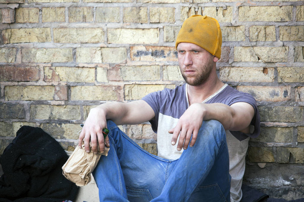  アルコール ボトルと悲しい落ち込んでいるホームレスの男性。社会的な問題 - 写真・画像