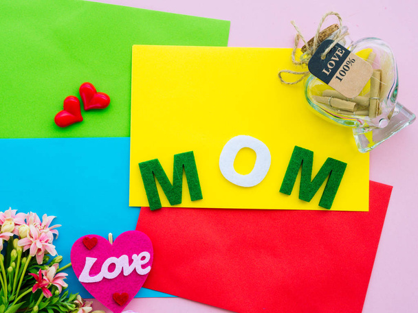 mother's day concept. MOM alphabet with marshmallow in the shape of heart and flower on background - Foto, imagen