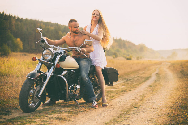 Szerelmesek egy motorkerékpár egy mezőben - Fotó, kép