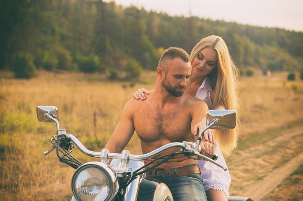 Szerelmesek egy motorkerékpár egy mezőben - Fotó, kép