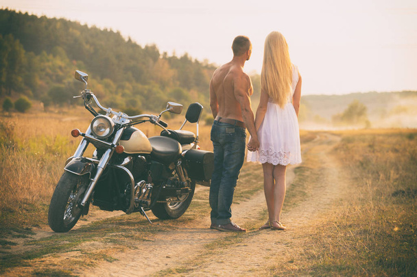 Amantes em uma motocicleta em um campo
 - Foto, Imagem
