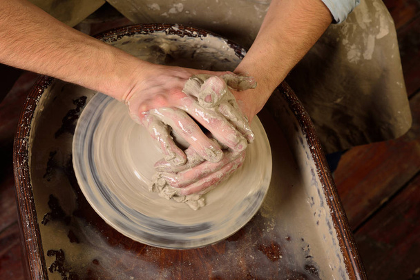 Mestre Crock. Mãos de homem a fazer jarro de barro. O escultor na wor
 - Foto, Imagem