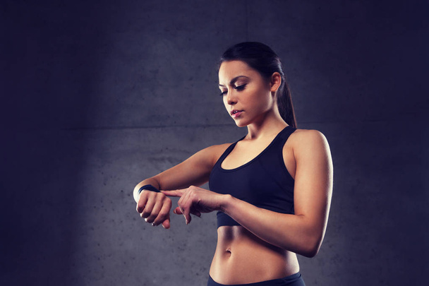 mujer joven con reloj de ritmo cardíaco en el gimnasio
 - Foto, imagen